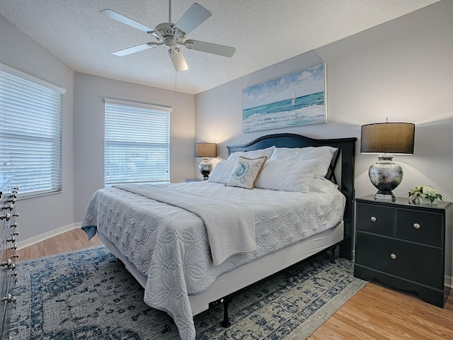 bedroom featuring ceiling fan, wood-type flooring, and a textured ceiling