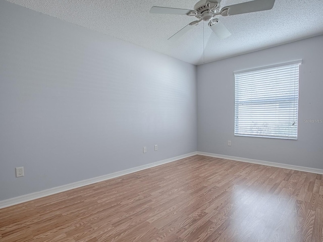 empty room with ceiling fan, light hardwood / wood-style flooring, and a textured ceiling