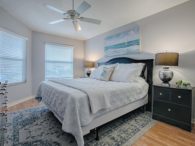 591 Statesburg St, The Villages, FL 32162 - bedroom featuring a textured ceiling, a ceiling fan, multiple windows, and light wood-style floors