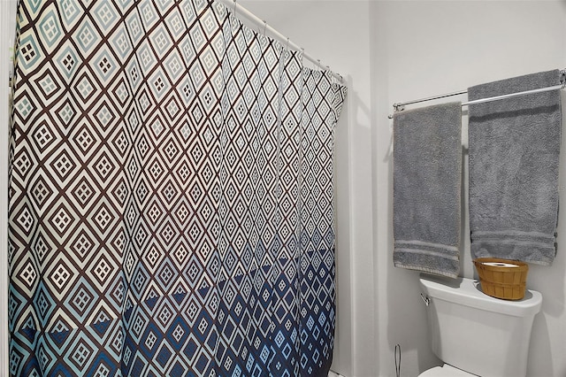 bathroom featuring curtained shower and toilet