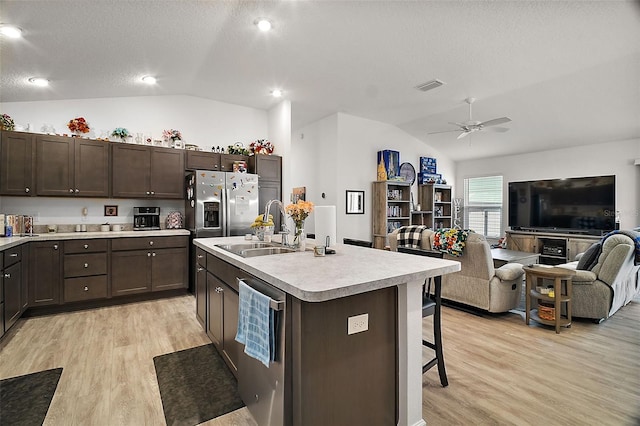 kitchen featuring a kitchen breakfast bar, dishwasher, an island with sink, lofted ceiling, and sink