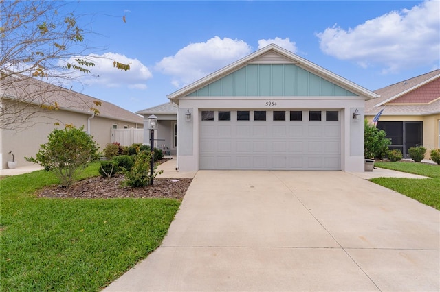 view of front of property with board and batten siding, a front yard, driveway, and a garage