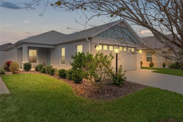 view of side of property featuring a garage, a yard, concrete driveway, and stucco siding