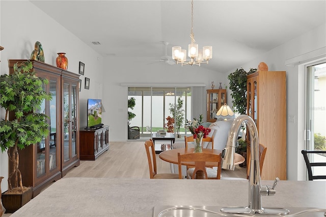 dining space featuring lofted ceiling, a notable chandelier, visible vents, and light wood-style floors