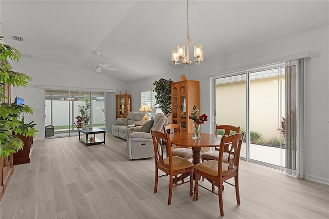 dining space featuring lofted ceiling, light wood-style flooring, visible vents, and ceiling fan with notable chandelier