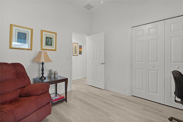 sitting room featuring baseboards, visible vents, and light wood finished floors