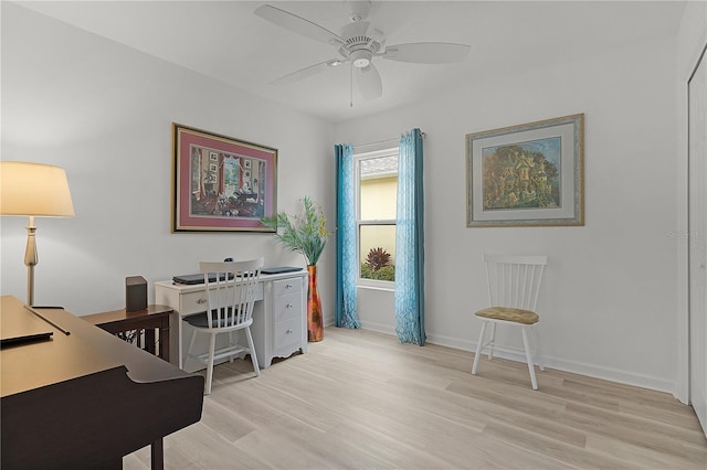 office space featuring ceiling fan, light wood finished floors, and baseboards