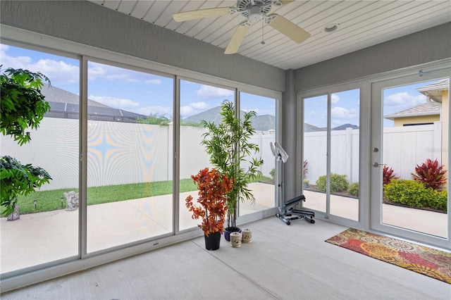 workout room with ceiling fan and a mountain view