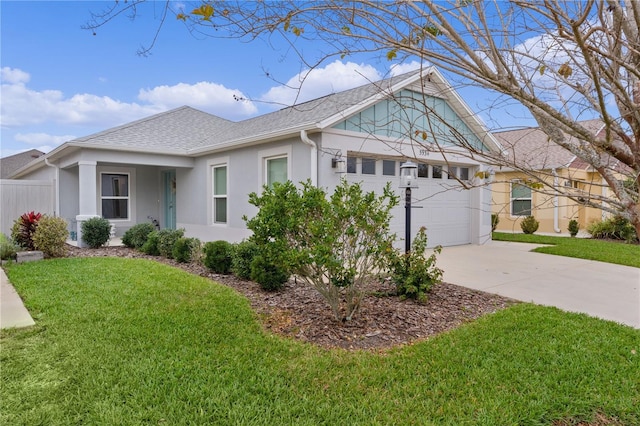 view of front of home featuring a front lawn, roof with shingles, an attached garage, and stucco siding