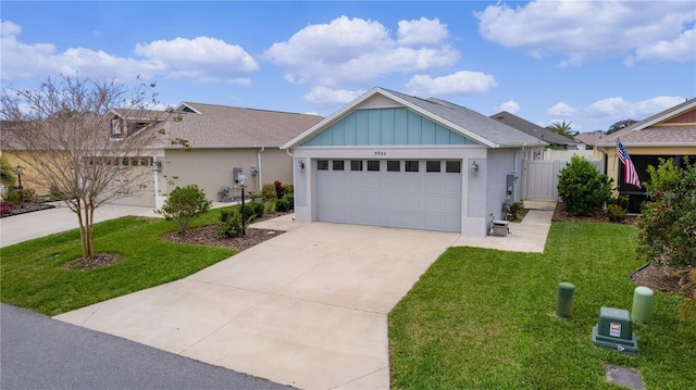 view of front of house with board and batten siding, concrete driveway, an attached garage, and a front lawn