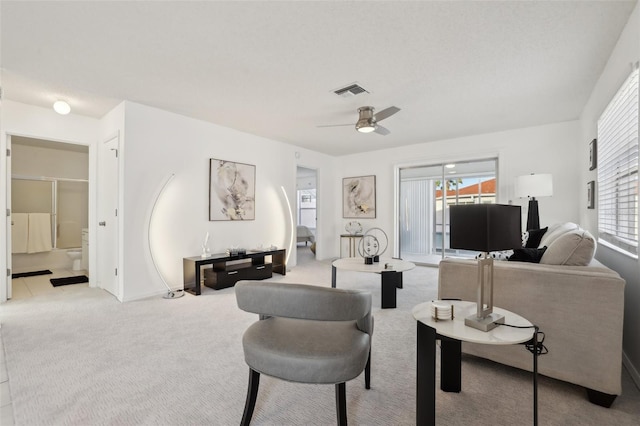 carpeted living room featuring visible vents and a ceiling fan