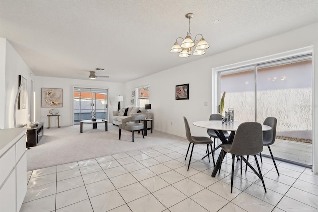 dining room featuring light carpet, a textured ceiling, and ceiling fan with notable chandelier