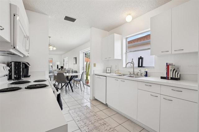 kitchen featuring white appliances, a sink, visible vents, white cabinetry, and light countertops