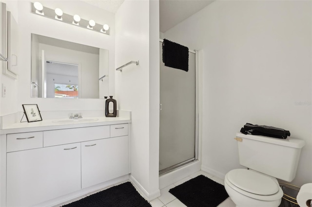 full bath featuring toilet, vanity, baseboards, a shower stall, and tile patterned floors