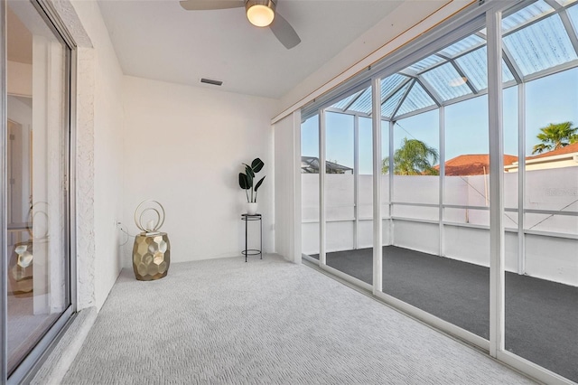 unfurnished sunroom with ceiling fan