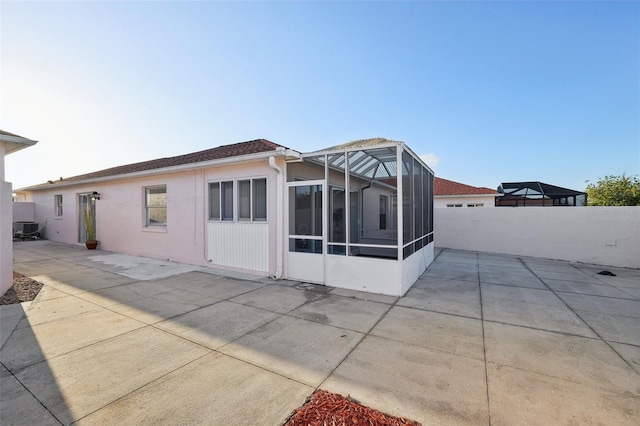 back of property with central AC, a patio area, and stucco siding