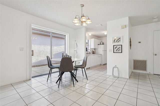 dining space with light tile patterned floors, visible vents, a textured ceiling, and an inviting chandelier