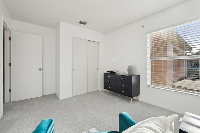 sitting room with light carpet, plenty of natural light, and visible vents