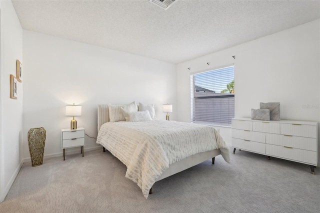 carpeted bedroom with baseboards, visible vents, and a textured ceiling