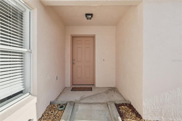 view of exterior entry with stucco siding