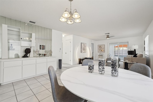 dining space featuring visible vents, light tile patterned flooring, and ceiling fan with notable chandelier