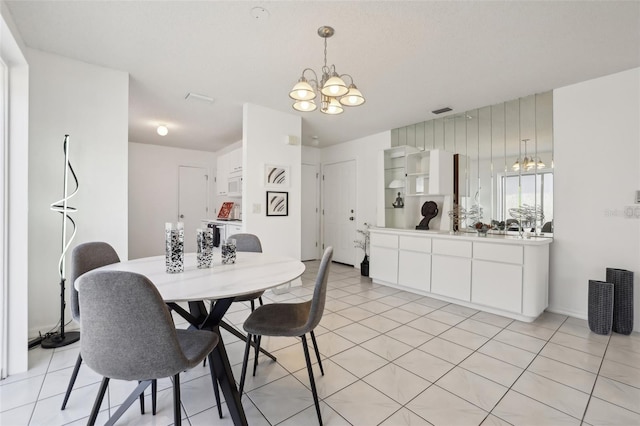 dining area with light tile patterned floors, visible vents, and a notable chandelier