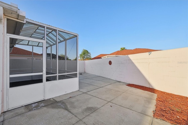 view of patio / terrace with glass enclosure and a fenced backyard