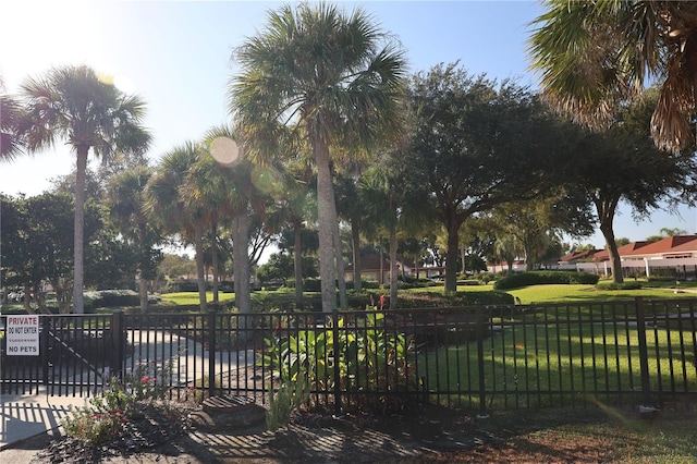 view of community with a lawn and fence