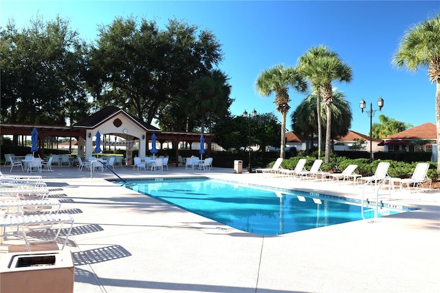pool with a patio and fence