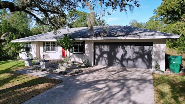 ranch-style home with a garage and a front lawn