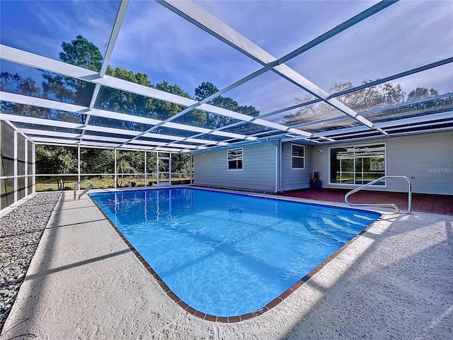 view of pool with a patio area and glass enclosure