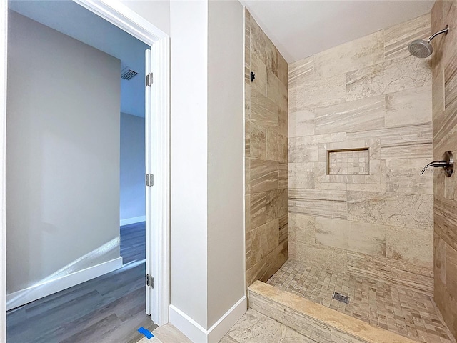 bathroom featuring tiled shower and hardwood / wood-style floors