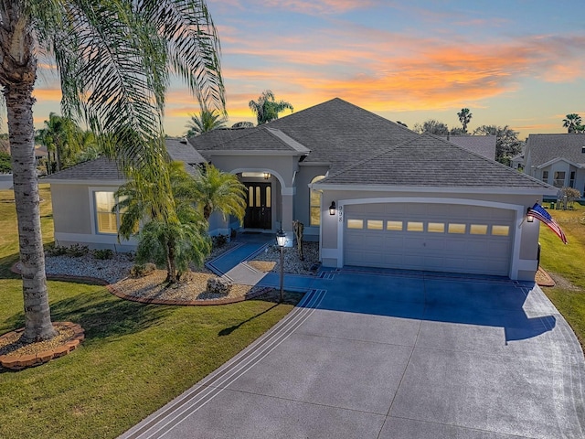 view of front of property featuring a shingled roof, a front lawn, and stucco siding