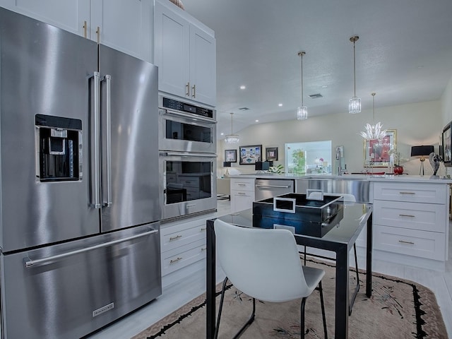 kitchen with appliances with stainless steel finishes, light countertops, and white cabinetry