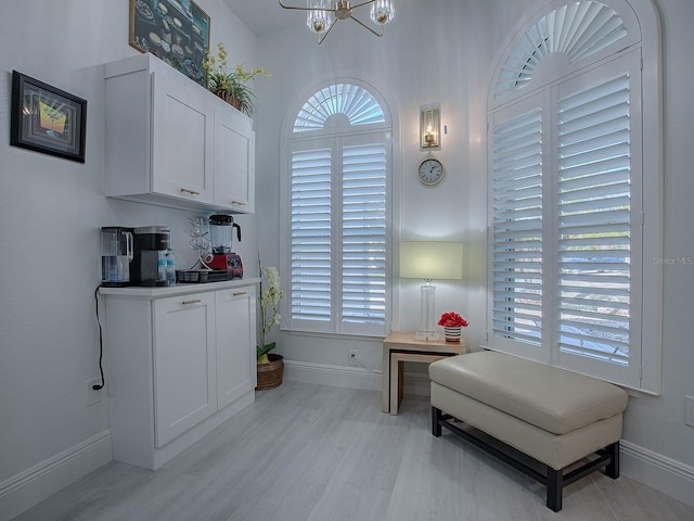 sitting room featuring an inviting chandelier and baseboards