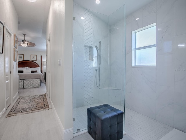 bathroom with baseboards, a walk in shower, a ceiling fan, and ensuite bathroom