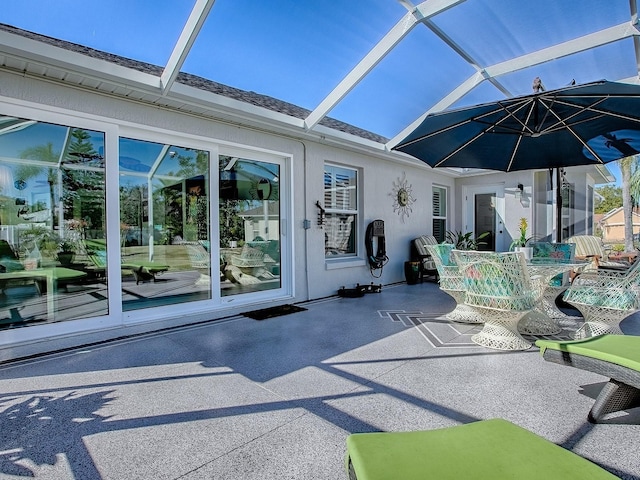 view of patio featuring glass enclosure