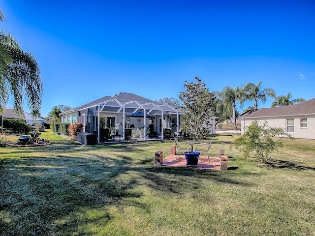 view of yard featuring glass enclosure and a patio