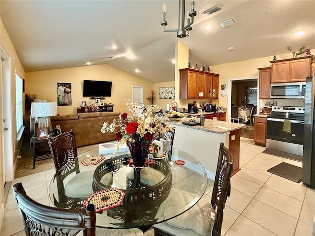 tiled dining room featuring vaulted ceiling