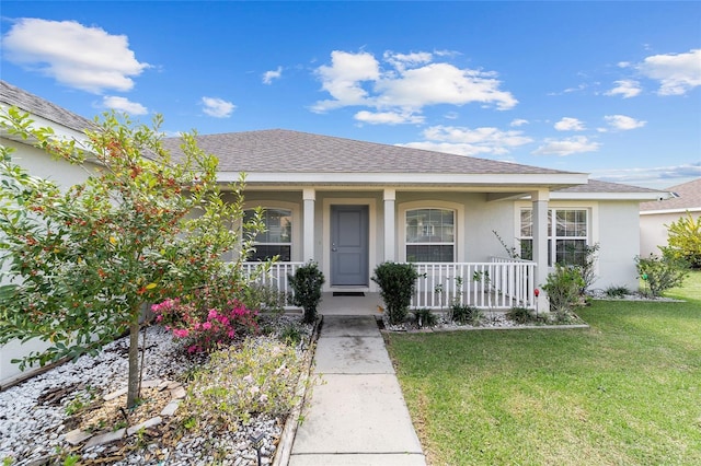 4000 SE 98th Pl, Belleview, FL 34420 - view of front of property featuring a front lawn, covered porch, roof with shingles, and stucco siding