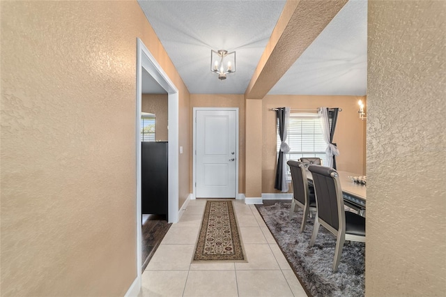 4000 SE 98th Pl, Belleview, FL 34420 - foyer entrance with a notable chandelier, light tile patterned floors, a textured wall, and baseboards
