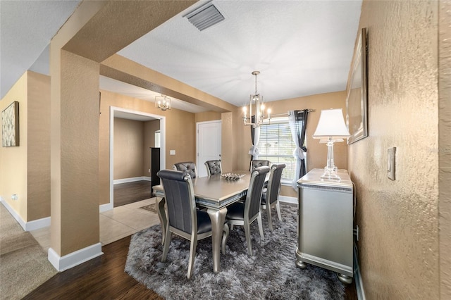 4000 SE 98th Pl, Belleview, FL 34420 - dining area featuring visible vents, baseboards, a chandelier, wood finished floors, and a textured wall
