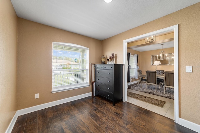 4000 SE 98th Pl, Belleview, FL 34420 - interior space with dark wood-style floors, baseboards, an inviting chandelier, and a textured wall