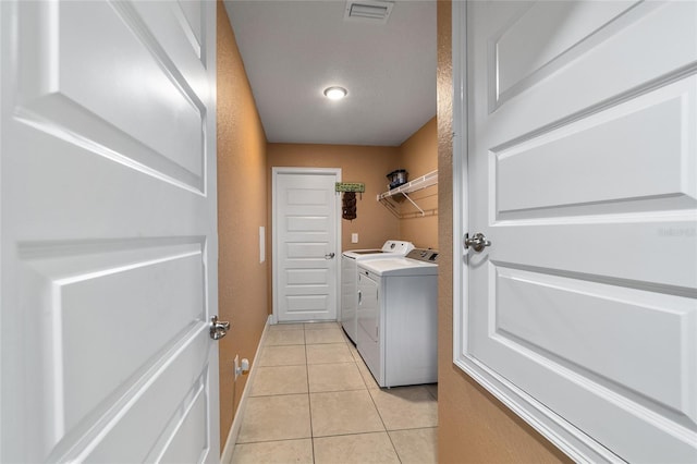 4000 SE 98th Pl, Belleview, FL 34420 - washroom featuring light tile patterned floors, visible vents, washing machine and dryer, and laundry area