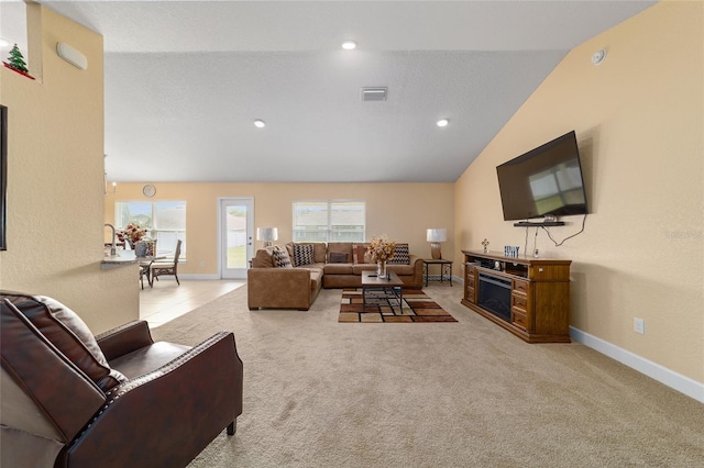 4000 SE 98th Pl, Belleview, FL 34420 - living area featuring visible vents, a healthy amount of sunlight, carpet, vaulted ceiling, and a fireplace