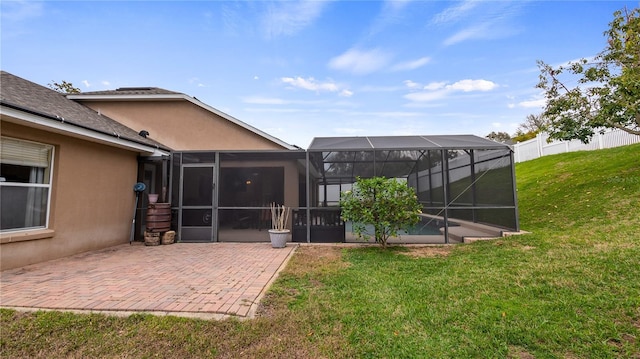 exterior space featuring a patio area, a yard, fence, and stucco siding