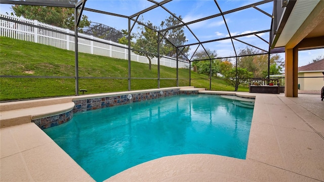 pool with a patio, a lanai, a jacuzzi, fence, and a yard