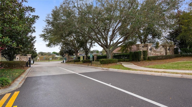 view of street featuring sidewalks, a gate, and curbs