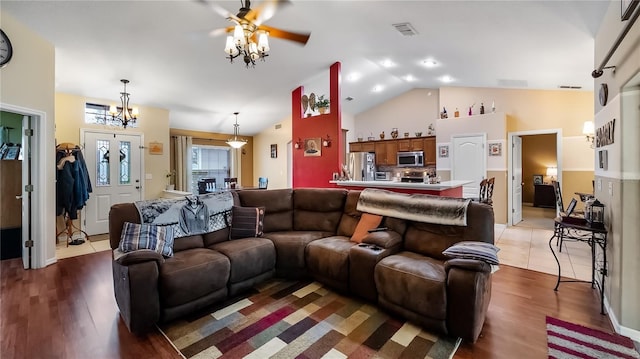 living room with high vaulted ceiling, light wood finished floors, and visible vents