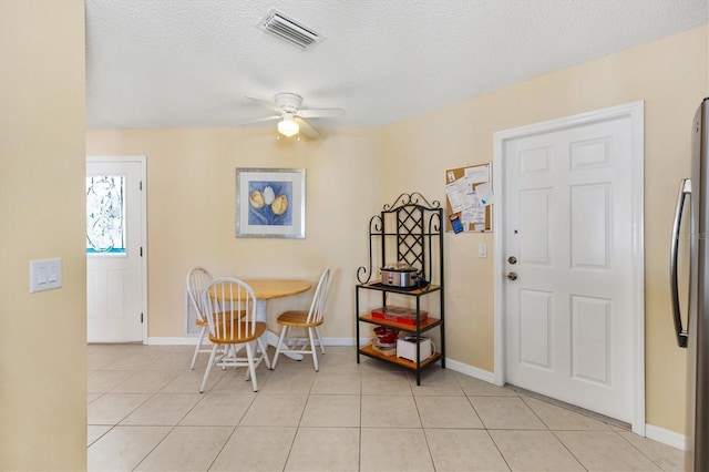 dining room with a textured ceiling, visible vents, a ceiling fan, and light tile patterned flooring